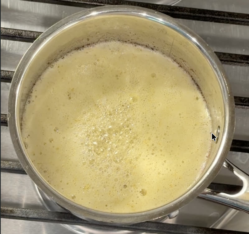Foam on top of the ghee being parted to check underneath